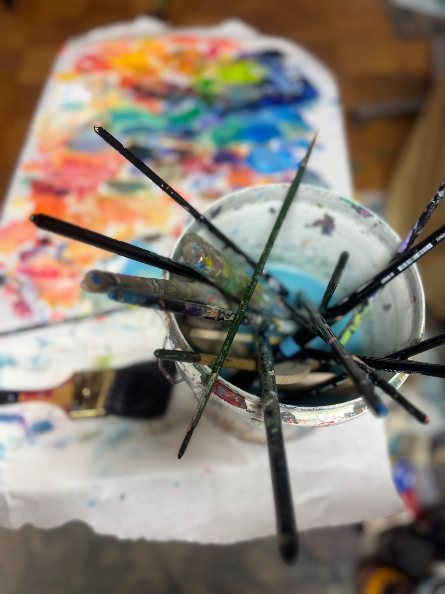 Paintbrushes beside Lisa’s colorful palette